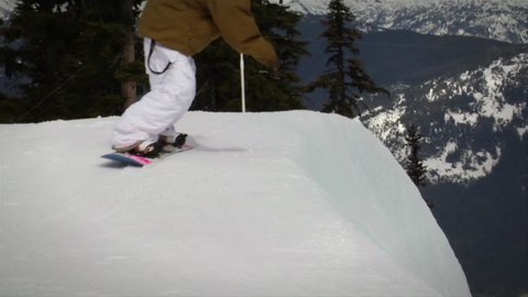 A montage of a snowboarder snowboarding, jumps and performs tricks while snowboarding in a halfpipe, various angles