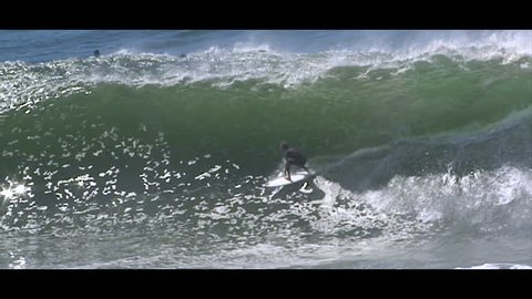 A surfer successfully tube riding a huge wave, slow motion