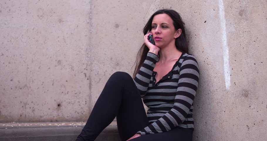 Girl sitting in stairwell on cell phone 4k