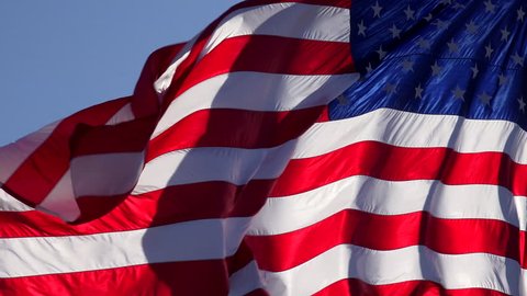 4K American flag waves free, unfurls, slowly in blue sky, light winds. 4K UHD, 3840x2160