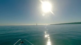 Motor boat on-board point-of-view footage. Forward view of the bow of a recreational power boat traveling towards a lighthouse. Location: Rangitoto Island Lighthouse, Hauraki Gulf, New Zealand.