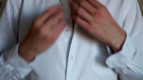 Man, male, boy, closeup buttoning his shirt. A man prepares to something going somewhere. Closeup of hands buttoning his shirt.
