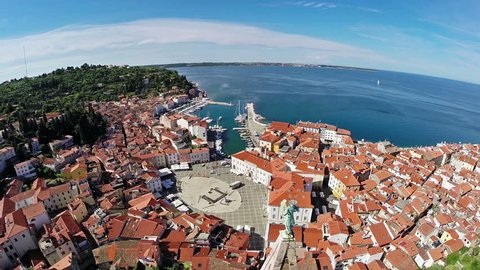 Flight over old city Piran, aerial panoramic view with church and the sea.