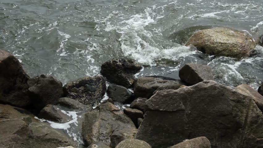 A small wave crashing on rocks. Santos, Sao Paulo, Brazil. Sao Paulos litoral coast.