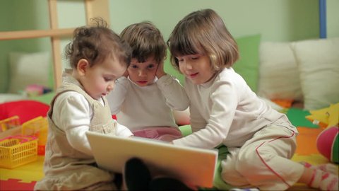 Happy children with laptop computer in kindergarten. Happy babies playing with pc at preschool. School and children education with kids and technology Stock Video