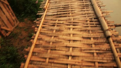 walking on dangerous bamboo bridge, laos