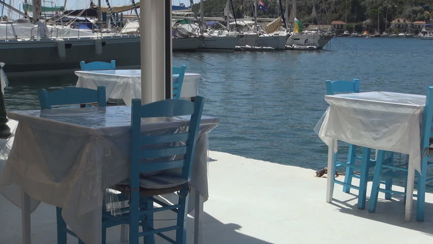 GREECE, LEFKADA, JULY 12, 2014, Restaurant with tables and chairs in a Mediterranea port, Summer day, Vacation