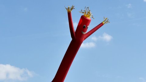 A shot of a red wacky waving inflatable arm flailing tube man.