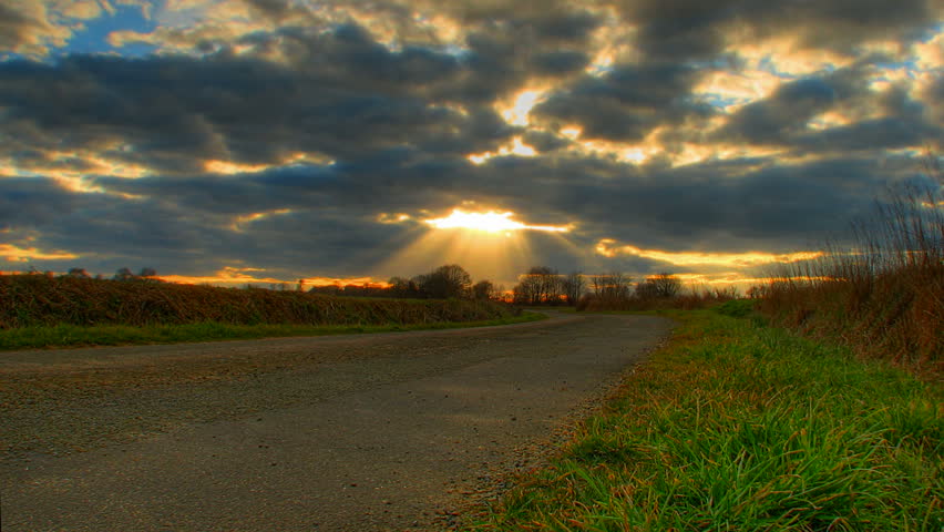 Motion time lapse of sunset clouds over road, high dynamic range imaging