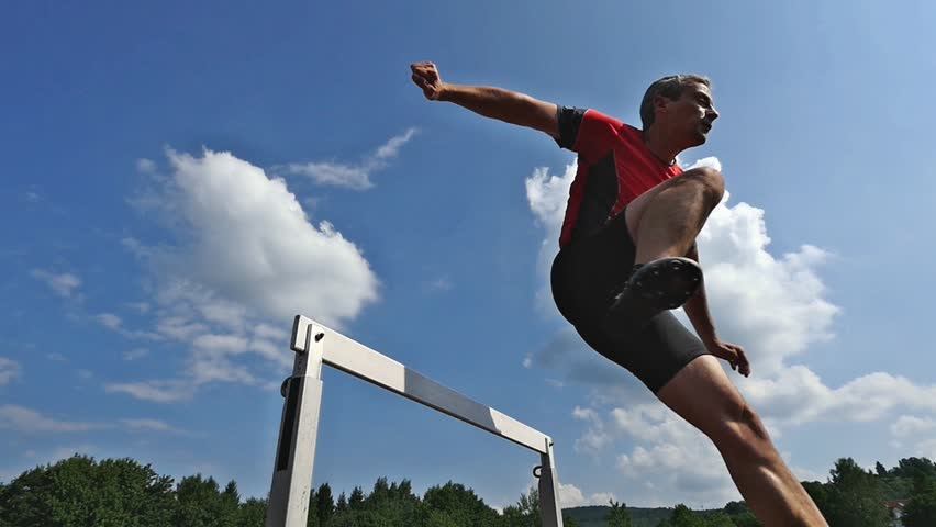 Athlete jumping over a hurdle in track and field in slow motion | Shutterstock HD Video #6950698
