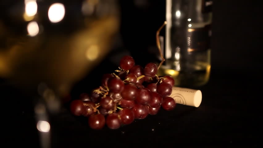 glass white wine with red grapes
