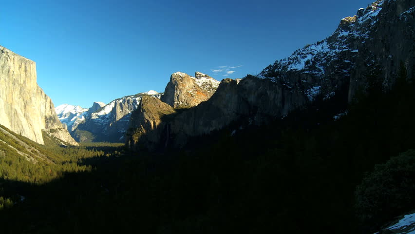 Valley, snow capped cliffs & forests of Yosemite National Park in winter