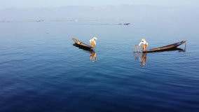 Myanmar, Inle Lake traditional fisherman from Intha ethnic group of Shan state fishing on wooden boat. Beautiful and scenic landscape HD 1080p video