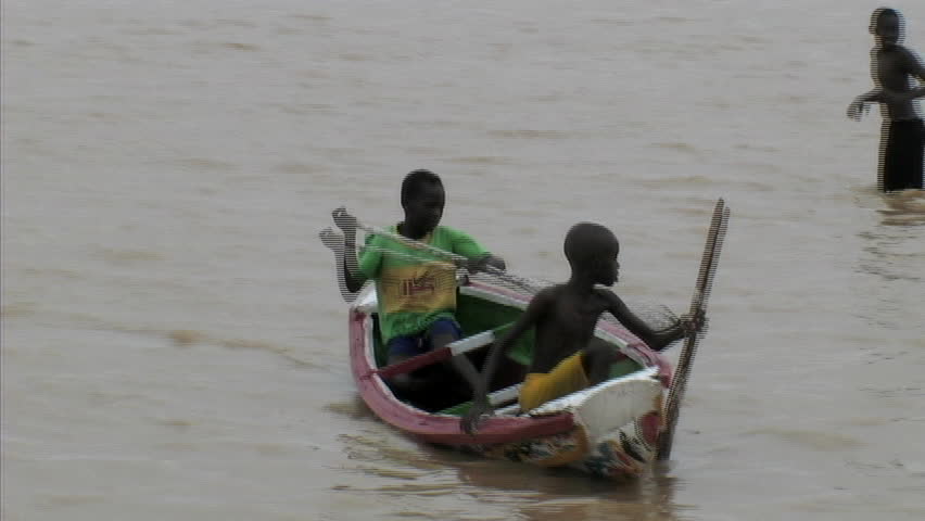 Kids rowing canoe in river