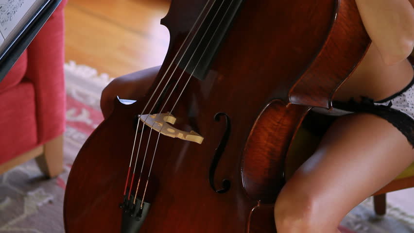 A beautiful cellist studies the music in detail.  