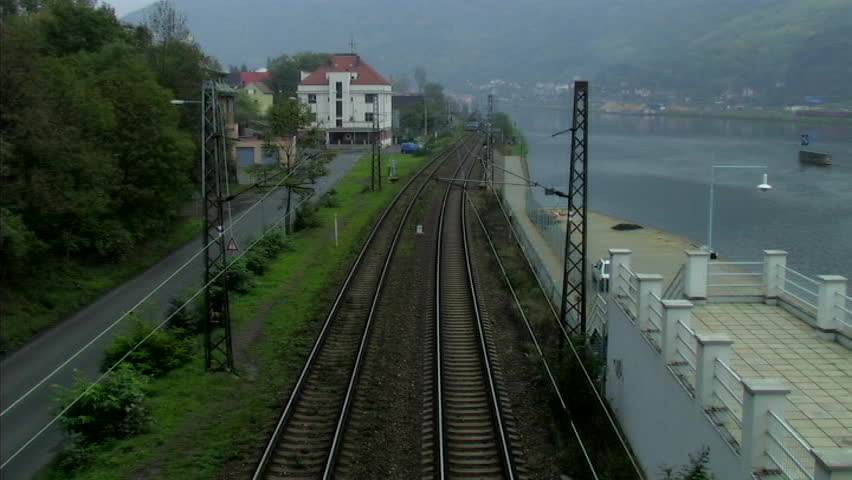Train coming toward camera next to river