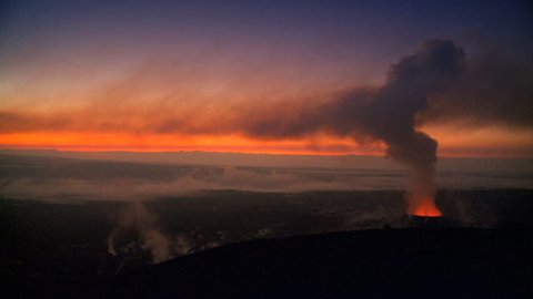 Sunset landscape behind steam billowing from an opening in a volcanic lava tube