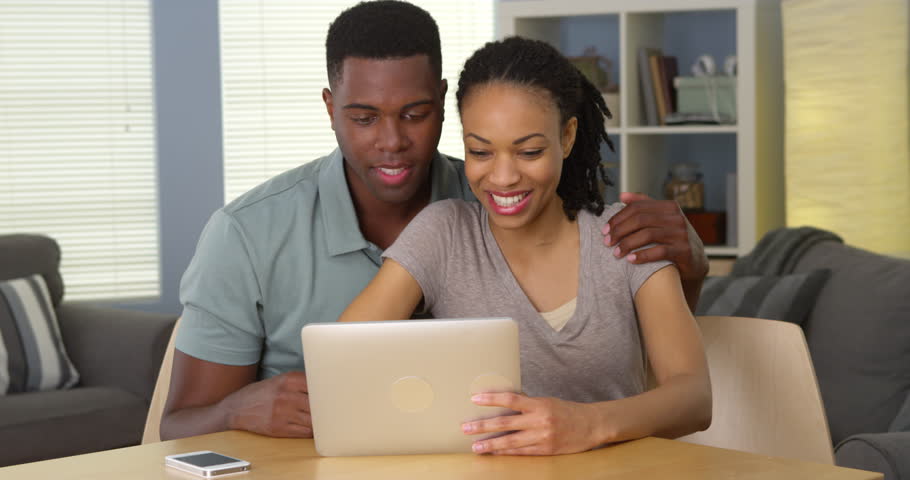 Smiling young black couple waving and having video chat with family over tablet | Shutterstock HD Video #6987139