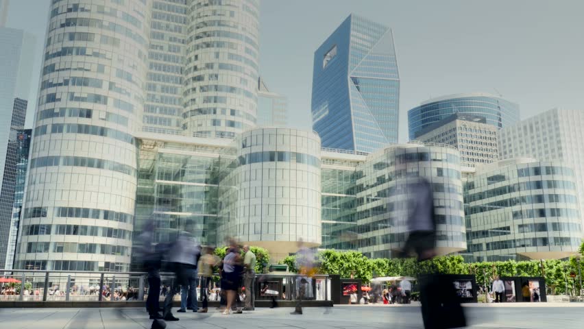 people crossing in front of camera. skyline buildings in the background