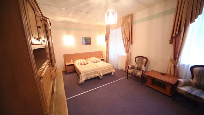 Light bedroom with double bed and white toilet and shower cabin