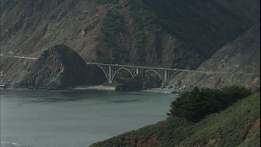 Zoom out of a bridge spanning cliffs in Big Sur, in California