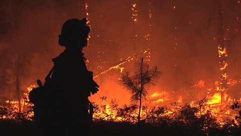 GLADIATOR FIRE, CROWN KING, ARIZONA - MAY 2012: Silhouette of firefighter observing fire at night