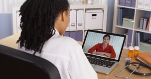 African American doctor talking to mature woman patient over video chat