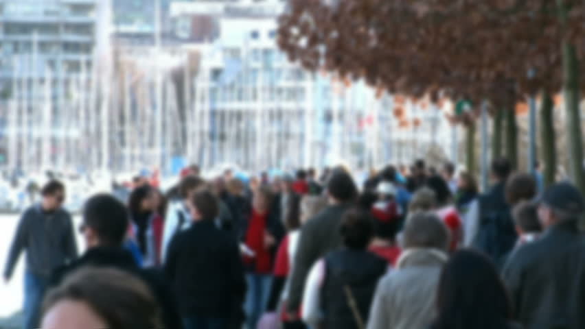 Many people walking by marina in Vancouver, Canada with soft focus effect.