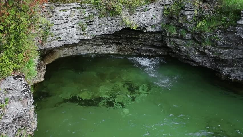 This seamless loop features the clear water of Lake Michigan splashing against limestone cliffs at Cave Point in Door County, Wisconsin.