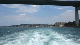 Passing under the Bosphorus Bridge in Istanbul Turkey. Shot from the back of a touristic boat. Recorded at normal speed.