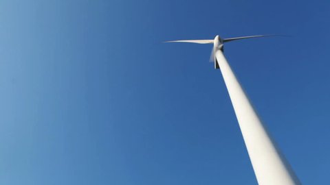 wind turbine in clear blue sky turning and turning