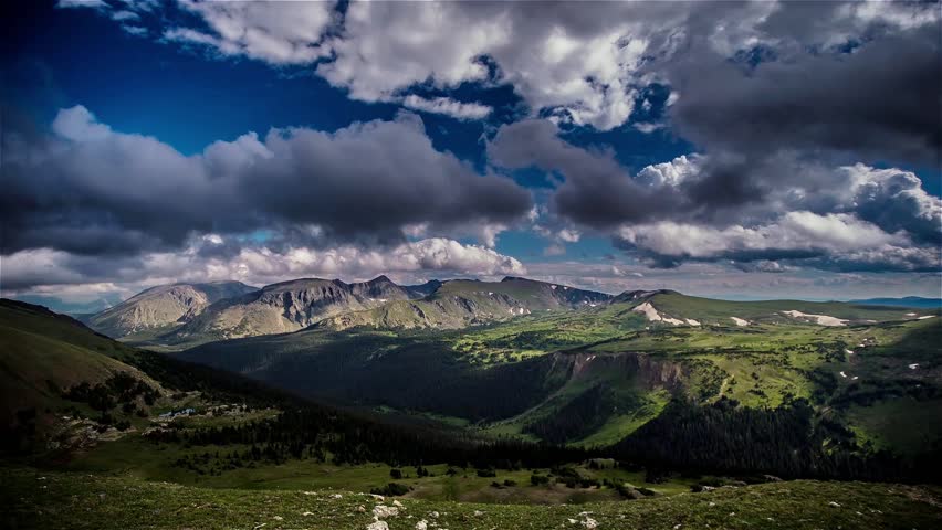 Trail Ridge Road overlooking Forest Canyon with clouds, blue skies and pine trees in Colorado Rocky Mountain National Park time lapse.