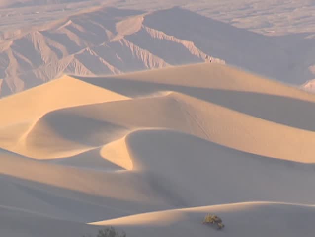 People in dust storm on a dune crest in Stovepipe Wells area, Death Valley. The strong, turbulent wind carries clouds of fine dust, soil, and sand over a large area, forming sand dunes.