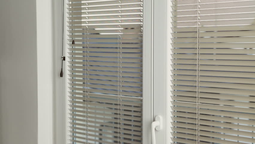 Young woman talking on the phone and looking through the window after taking shower