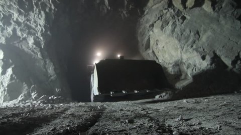 ANTOFAGASTA, CHILE - INTERIOR MINE - A Caterpillar 416E Retro Excavator drives through the tunnel of a mine towards the camera. Adlı Haber Amaçlı Stok Video