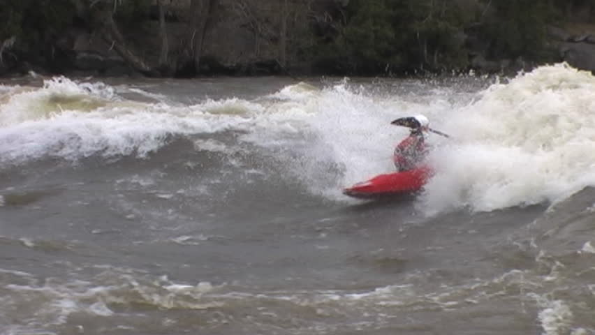 A man in a kayak surfs on a wave in the river and does tricks | Shutterstock HD Video #7025188