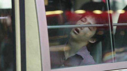 HONG KONG, CIRCA 2014: Asian tired sleeping man in the city bus