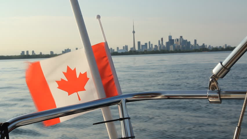 Sailing in Toronto.
View of sailboat stern with Canadian flag and Toronto in the distance. Toronto, Ontario, Canada.
