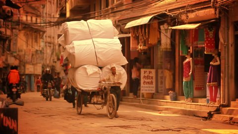 KATHMANDU, NEPAL, CIRCA MAY 2014 – Man transports large load of freight on a tricycle circa May 2014 in Kathmandu, Nepal. Kathmandu is the capital and largest urban agglomerate of Nepal.