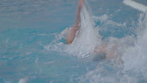 slow motion of professional swimmer swimming the crawl in outdoor pool