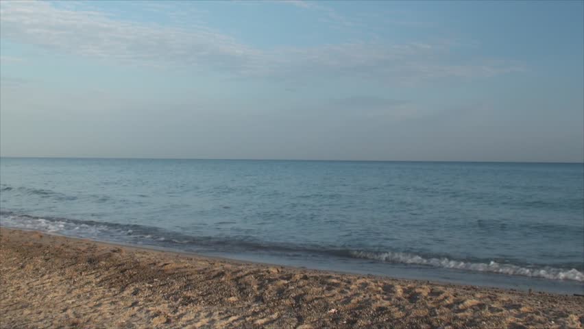 Woman in black runs through lake beach. Early morning footage.
