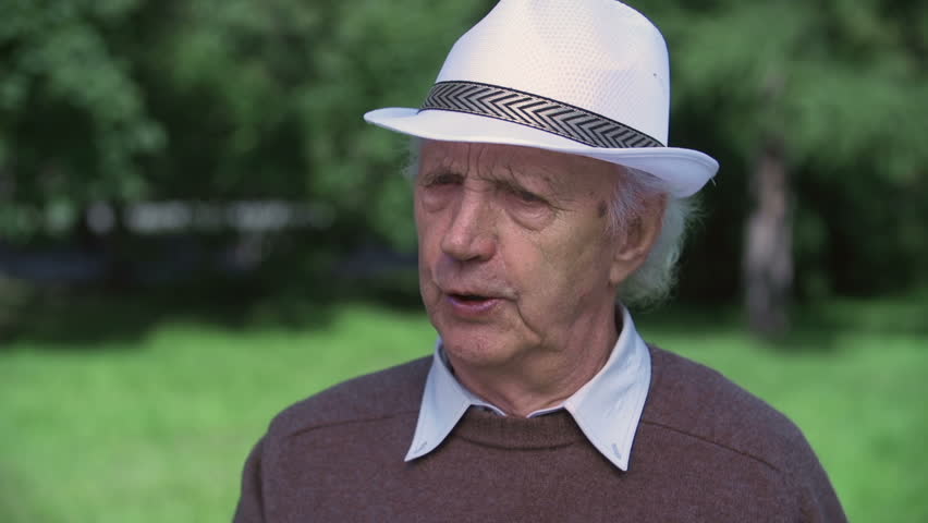 Close up of elderly man finishing his song and looking straight at camera smiling
