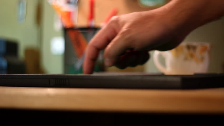 A man uses a tablet PC on his office desk.