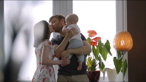 Young father plays with baby - Young family at the window Stockvideo