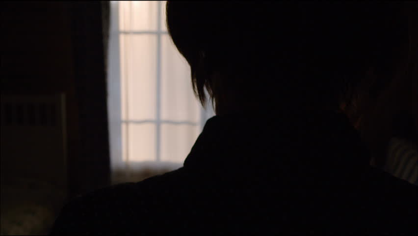 Young woman opens the window indoors