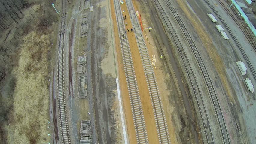 Building site of railway tracks among forest with city at horizon. Aerial view