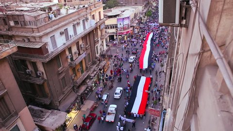 Overhead view of protestors carrying banners and marching in the streets of Cairo, Egypt.