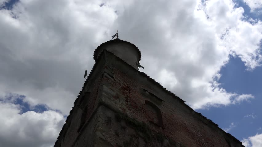 White fluffy sky on blue sky over an old fortress