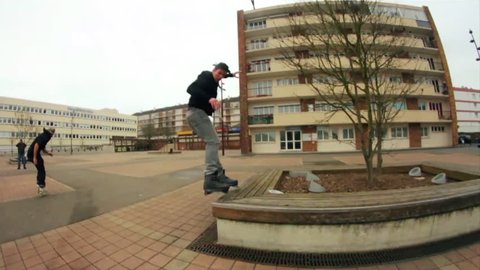 A traceur shows various jumps while running on a pavement, backflip, cartwheel, various skaters visible around him, slow motion