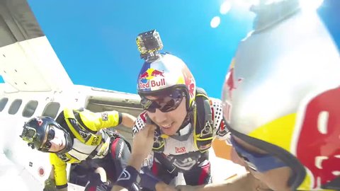 Skydivers jump from an aircraft, showcases a formation while skydiving before breaking the formation , POV